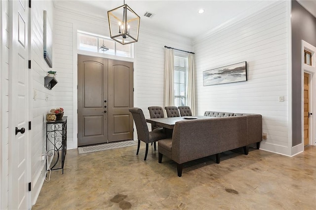 531 N Caleb Dr, Slidell, LA 70461 - dining space with finished concrete floors, a chandelier, and wood walls