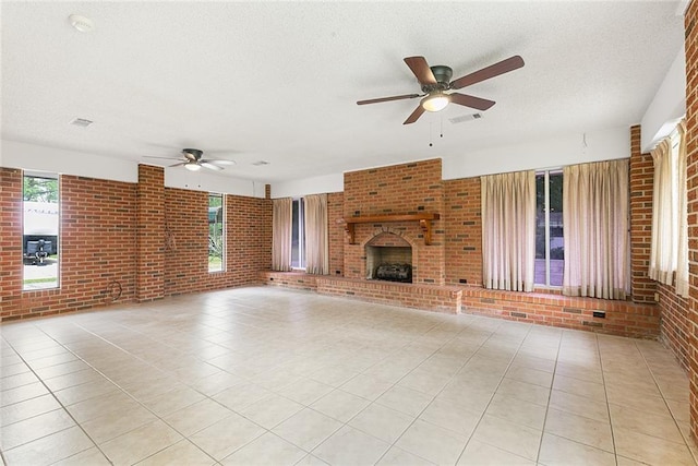47116 N Morrison Blvd, Hammond, LA 70401 - unfurnished living room with visible vents, brick wall, a fireplace, ceiling fan, and a textured ceiling