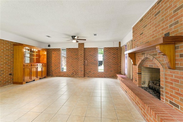 47116 N Morrison Blvd, Hammond, LA 70401 - unfurnished living room featuring a ceiling fan, a textured ceiling, a brick fireplace, and brick wall