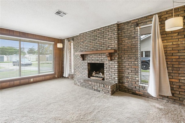 47116 N Morrison Blvd, Hammond, LA 70401 - unfurnished living room featuring a textured ceiling, visible vents, a brick fireplace, wood walls, and carpet