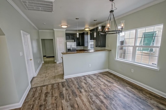 kitchen featuring stainless steel fridge with ice dispenser, crown molding, visible vents, and a notable chandelier