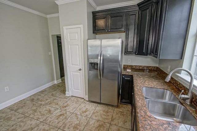 kitchen featuring stainless steel refrigerator with ice dispenser, crown molding, light tile patterned floors, baseboards, and a sink
