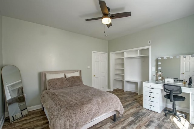bedroom with baseboards, a closet, wood finished floors, and ceiling fan
