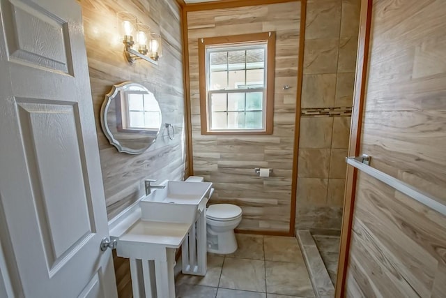 bathroom featuring toilet, vanity, tile patterned flooring, and tiled shower
