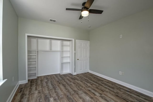 unfurnished bedroom featuring a closet, visible vents, baseboards, ceiling fan, and dark wood-type flooring