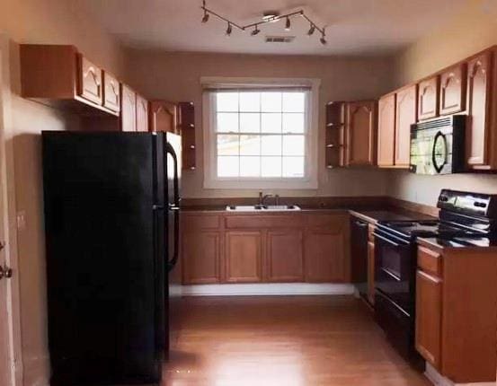 313840 Louisiana Ave Parkway, New Orleans, LA 70125 - kitchen featuring black appliances, a sink, light wood-style flooring, and dark countertops