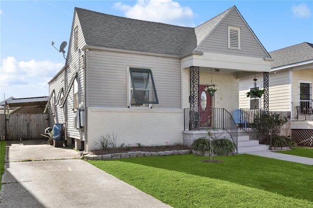 4718 Annette St, New Orleans, LA 70122 - view of front of house featuring brick siding, a shingled roof, fence, and a front lawn