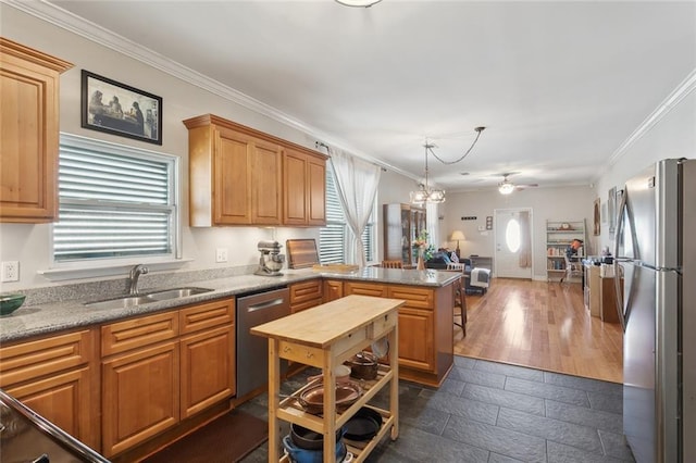 4718 Annette St, New Orleans, LA 70122 - kitchen featuring a peninsula, ornamental molding, stainless steel appliances, a sink, and open floor plan
