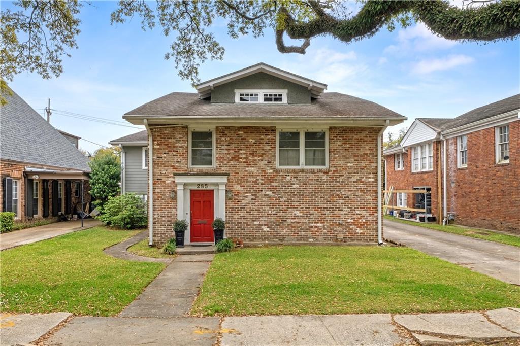 view of front of property with brick siding and a front lawn