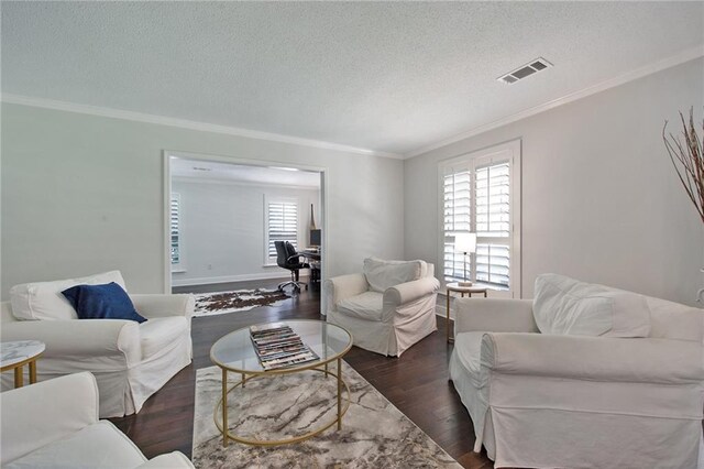 living area featuring visible vents, a textured ceiling, ornamental molding, and wood finished floors