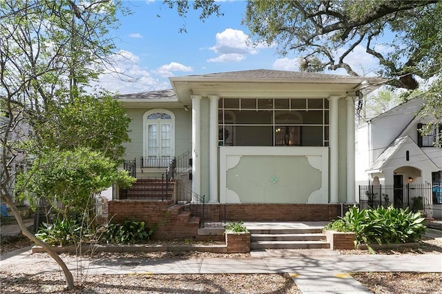 710 Burdette St, New Orleans, LA 70118 - view of front of house featuring a sunroom, fence, and roof with shingles