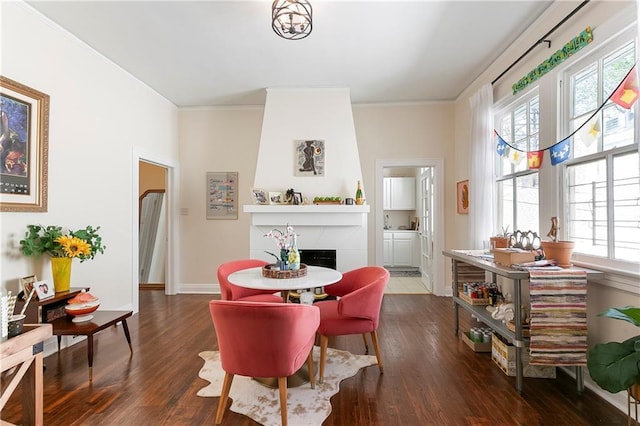 710 Burdette St, New Orleans, LA 70118 - dining area featuring baseboards, a fireplace, crown molding, and dark wood-type flooring