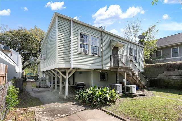 710 Burdette St, New Orleans, LA 70118 - view of front of home featuring stairway, fence, a front lawn, central AC, and a patio area