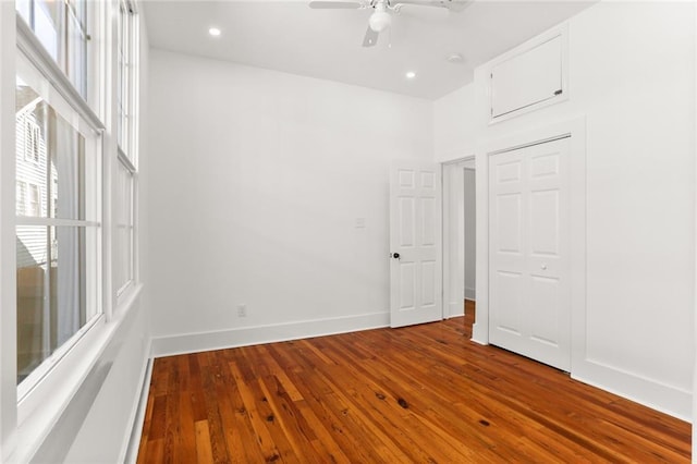 unfurnished bedroom with a closet, baseboards, ceiling fan, recessed lighting, and hardwood / wood-style floors