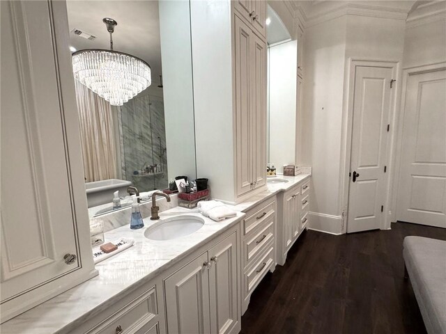 full bathroom featuring vanity, crown molding, a stall shower, a notable chandelier, and wood finished floors