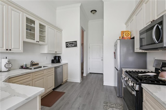 227 Riverlands Dr, La Place, LA 70068 - kitchen with stainless steel appliances, light wood-style floors, light stone countertops, crown molding, and glass insert cabinets