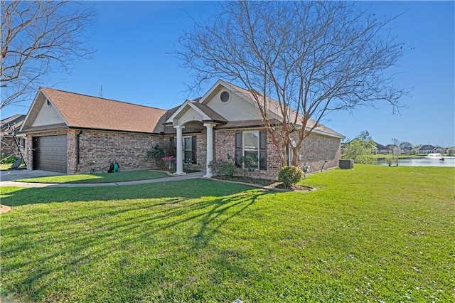 313 Oak Point Dr, La Place, LA 70068 - single story home with brick siding, a front lawn, a garage, a water view, and central AC
