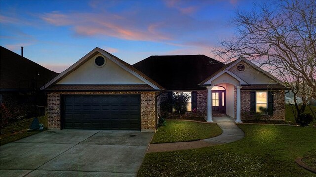 313 Oak Point Dr, La Place, LA 70068 - view of front of property with brick siding, driveway, a yard, and an attached garage