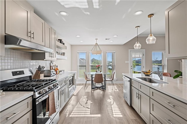 313 Oak Point Dr, La Place, LA 70068 - kitchen featuring stainless steel appliances, under cabinet range hood, a sink, decorative backsplash, and recessed lighting
