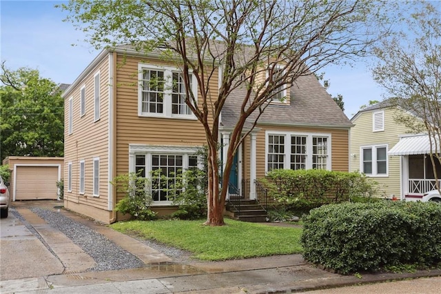 view of front of home featuring an outdoor structure, a front yard, and concrete driveway