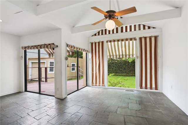 unfurnished room featuring stone tile floors, a ceiling fan, baseboards, and lofted ceiling