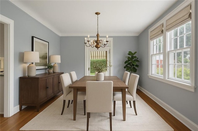 dining room featuring an inviting chandelier, wood finished floors, and baseboards