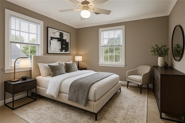 bedroom with light carpet, a ceiling fan, and baseboards
