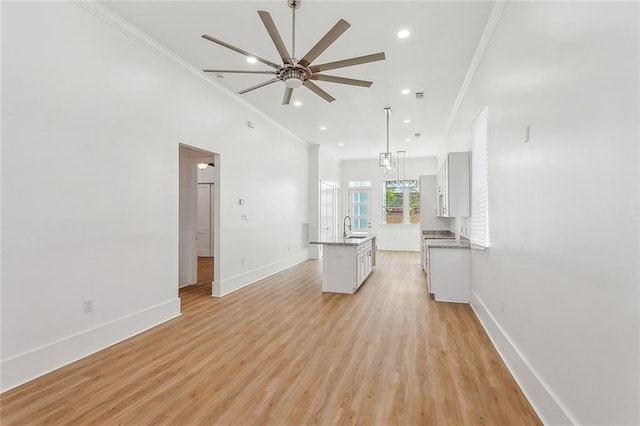 2460 N Villere St, New Orleans, LA 70117 - unfurnished living room featuring a ceiling fan, baseboards, crown molding, light wood-type flooring, and recessed lighting