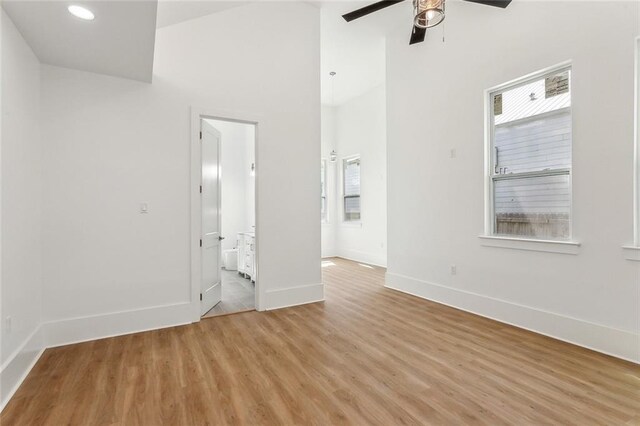 2460 N Villere St, New Orleans, LA 70117 - unfurnished room featuring ceiling fan, baseboards, plenty of natural light, light wood-style floors, and high vaulted ceiling