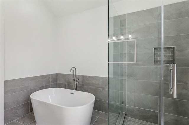 2460 N Villere St, New Orleans, LA 70117 - bathroom with tile walls, a stall shower, a freestanding tub, and wainscoting