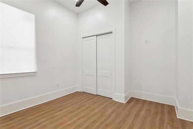 2460 N Villere St, New Orleans, LA 70117 - unfurnished bedroom featuring light wood-style flooring, baseboards, a closet, and ceiling fan