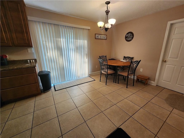 dining room featuring light tile patterned floors, baseboards, and a chandelier