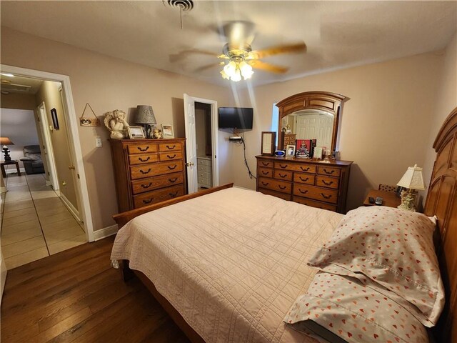 bedroom with baseboards, ceiling fan, and wood finished floors