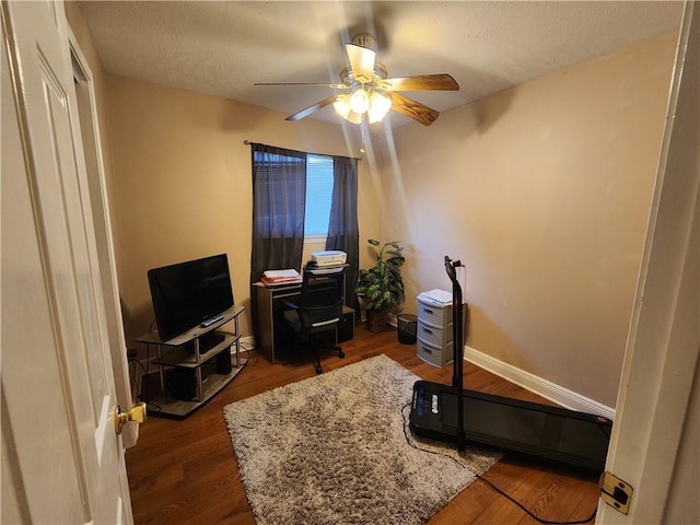 office with baseboards, a textured ceiling, wood finished floors, and a ceiling fan