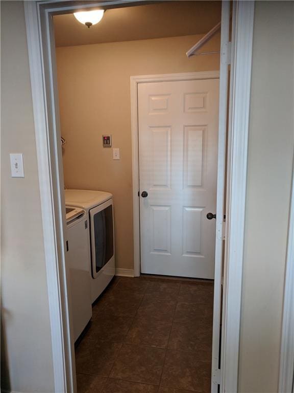 laundry area with independent washer and dryer, laundry area, and dark tile patterned flooring