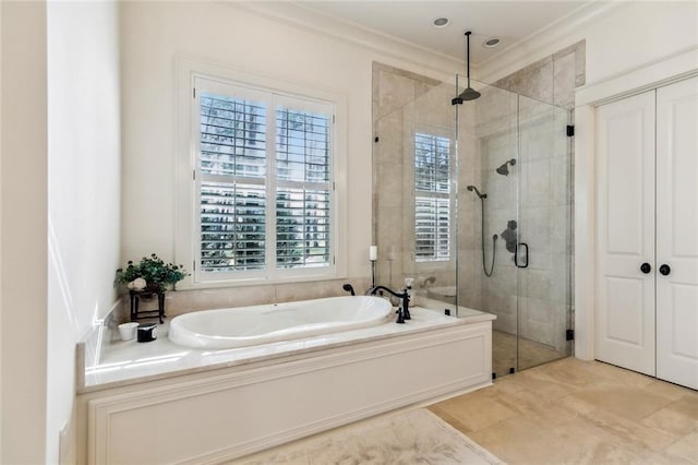 bathroom with a shower stall, ornamental molding, and a garden tub