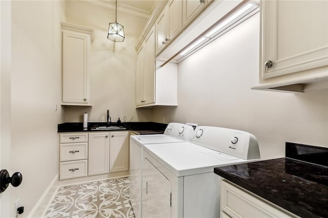 clothes washing area with a sink, light tile patterned floors, baseboards, washer and dryer, and cabinet space