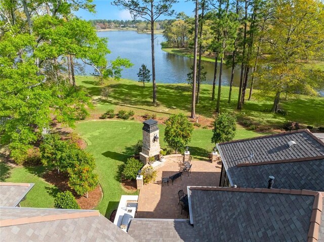 view of property's community with a water view, a patio area, and a yard