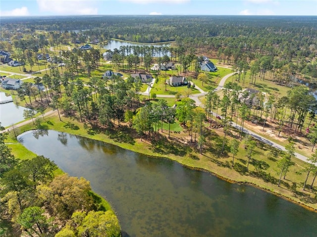 drone / aerial view with a water view and a wooded view