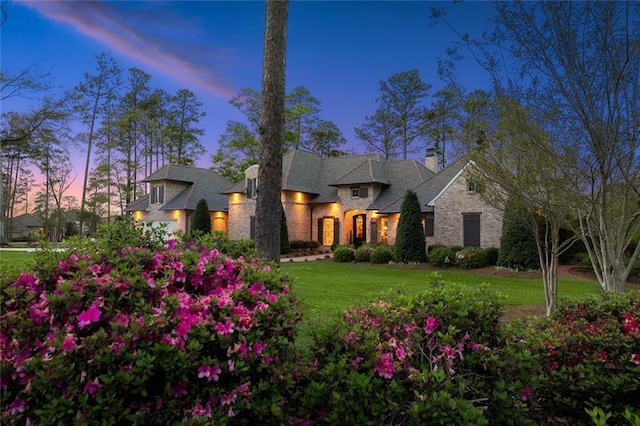 french country inspired facade with a front lawn