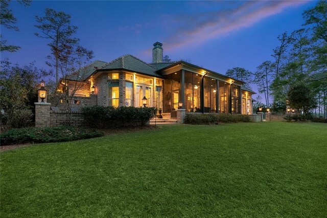 rear view of property with a lawn and a chimney
