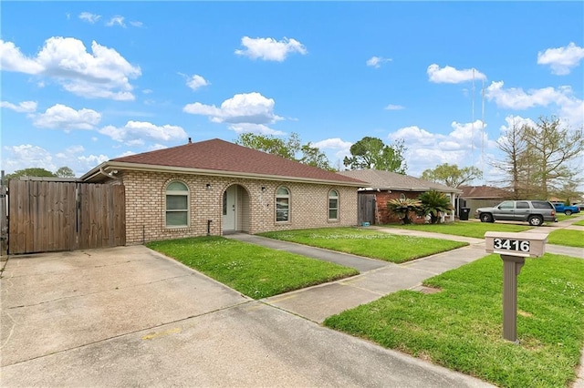 3416 Dauterive Dr, Chalmette, LA 70043 - view of front of home featuring a shingled roof, fence, brick siding, a front lawn, and a gate