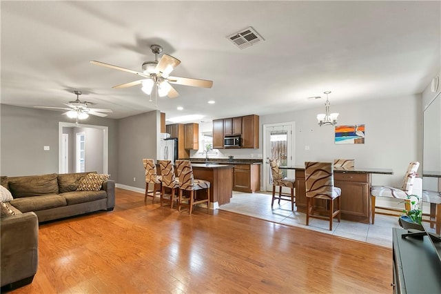 3416 Dauterive Dr, Chalmette, LA 70043 - living room featuring baseboards, recessed lighting, visible vents, light wood finished floors, and ceiling fan with notable chandelier