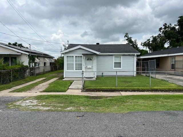view of front of property with a fenced front yard and a front lawn
