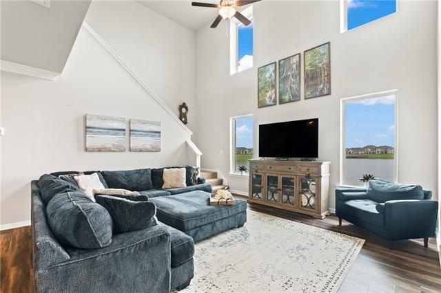 405 Short Bough Ln, Slidell, LA 70461 - living room featuring ceiling fan, wood finished floors, stairway, and a towering ceiling