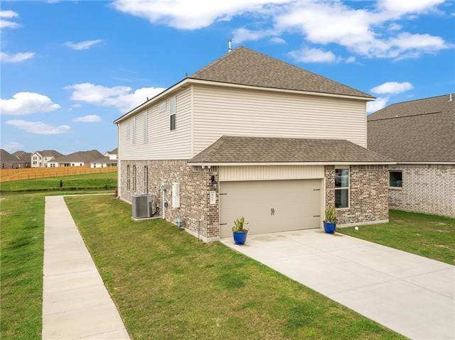 405 Short Bough Ln, Slidell, LA 70461 - view of side of home with brick siding, a yard, concrete driveway, and roof with shingles
