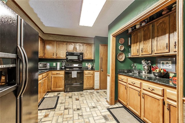 706 Natalie Dr, Houma, LA 70364 - kitchen featuring brick floor, black appliances, dark stone countertops, and a sink