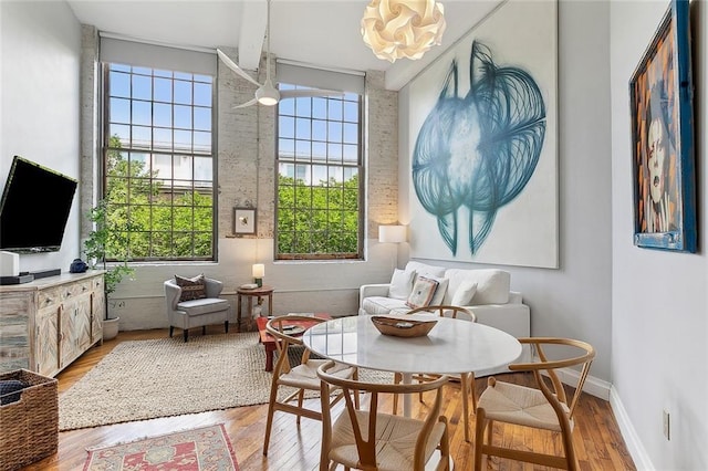 living area featuring a water view, baseboards, a healthy amount of sunlight, and wood finished floors