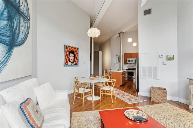 living room with high vaulted ceiling, baseboards, dark wood-style flooring, and visible vents