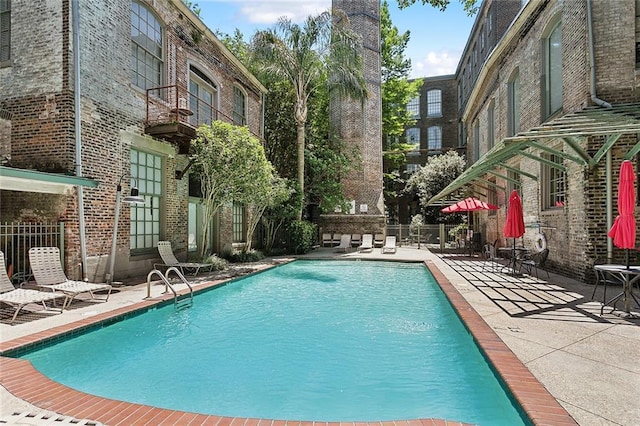 community pool featuring fence and a patio area
